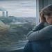 Woman sitting by a window looking distressed while pollution, syringes, and processed food imagery appear in the background