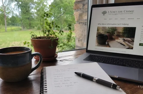 A quiet desk with coffee, notebook, laptop, and the A Voice For Change website open, reflecting information overload and the need for calmer health decisions.