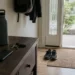 Entryway with walking shoes, water bottle, keys, and phone face-down, representing healthy boundaries, consistency, and daily health choices.