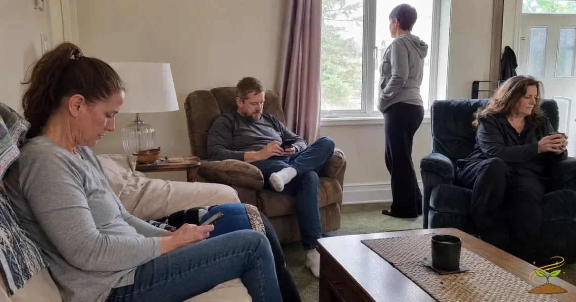 Four adults sitting together in a living room while looking at phones or away from one another, representing feeling disconnected.